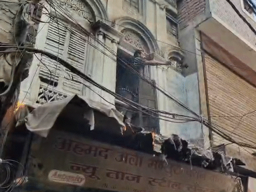 व्यापारी ने मग में पेट्रोल भर रखा था। नीचे खड़े लोग उसे समझाते रहे।