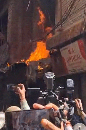आग भड़कने पर लोग डर गए। पुलिस फोर्स सीढ़ियों के सहारे में मकान में दाखिल हुई है।