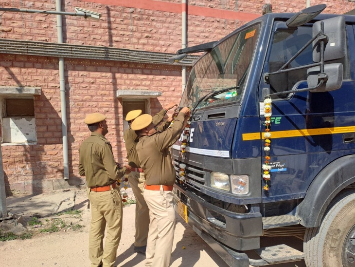 गाड़ी को फूलों से सजाते हुए पुलिसकर्मी। इसी में बाद में पुलिस लाइन तक मृतक कांस्टेबल का शव ले जाया गया।