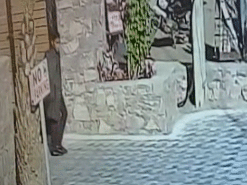 शादी समारोह से कोट में बैग छिपाकर निकलता हुआ एक युवक