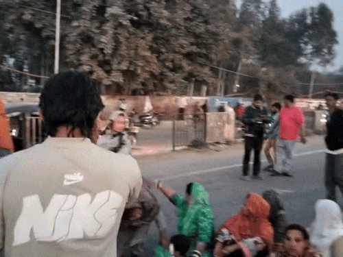 सड़क पर बैठे लोग।