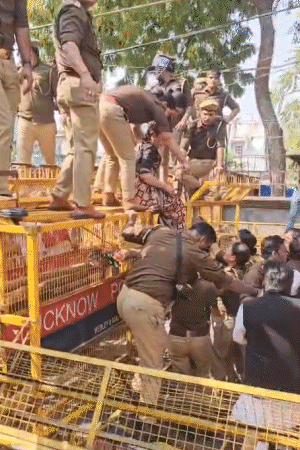 महिला पुलिसकर्मियों ने विधायक आराधना को बैरिकेडिंग से उतारकर बस में बैठाया।