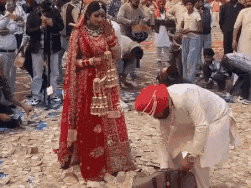 दूल्हे ने बैग से नोटों की गड्डियां निकाल-निकालकर नोट उड़ाए।