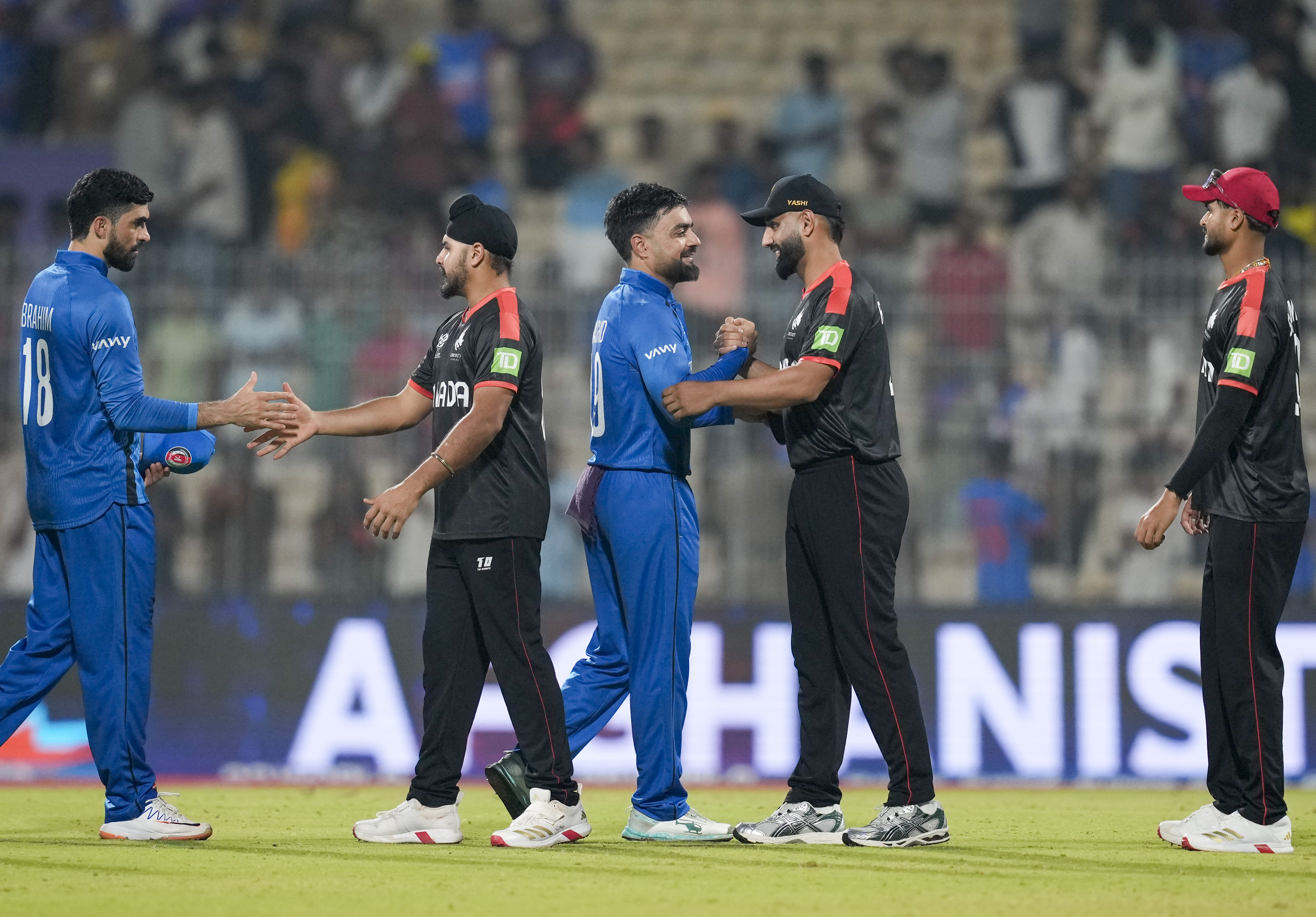 જીત બાદ કેનેડાના ખેલાડીઓ સાથે હાથ મિલાવતા અફઘાનિસ્તાનના કેપ્ટન રાશિદ ખાન.