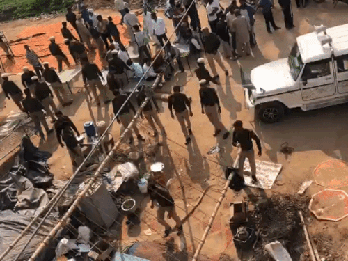 धरनास्थल से तंबू उखाड़ने के बाद किसानों की खाट उठाकर ले जाते पुलिसकर्मी।