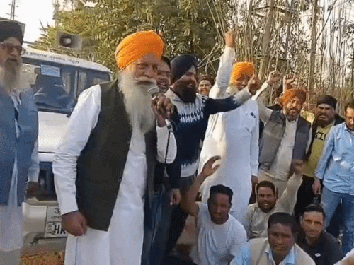 प्रशासन के खिलाफ नारेबाजी करते किसान नेता गुरनाम सिंह चढ़ूनी और साथ में धरने पर बैठे किसान।
