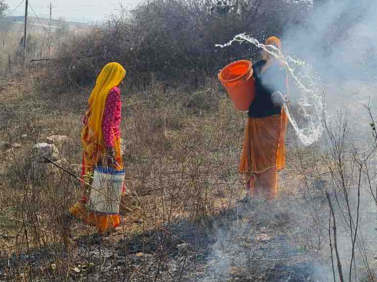 महिलाओं ने बाल्टियों से आग पर काबू पाने की कोशिश की।