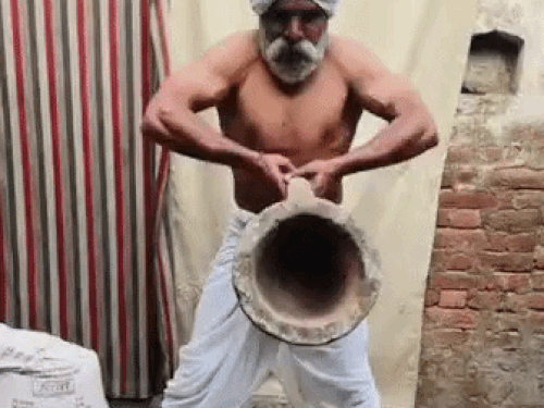 पुराने पत्थर की औखली को उठाकर एक्सरसाइज करते संजय उर्फ काला पहलवान।