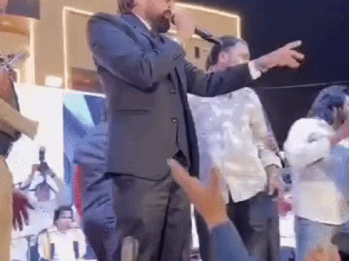 Before coming towards the stage, Masoom Sharma signals to his companion to stop the Sarpanch and the youth.