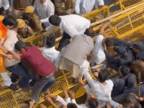 पुलिस से झड़प के दौरान बैरिकेडिंग से नीचे गिरे बीजेपी कार्यकर्ता।