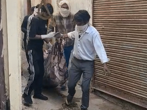 वृद्ध महिला के शव को निकालकर ले जाती पुलिस।