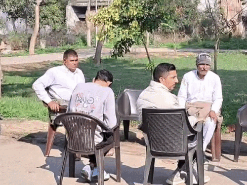 Family members and others sitting outside his residence after receiving information about the ASI's death.