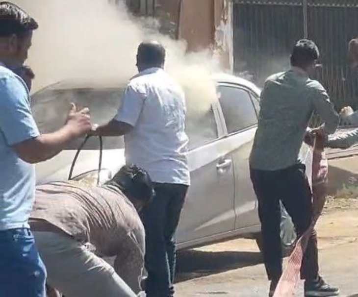 पाली के बालिया स्कूल के सामने खड़ी कार में अगी आग को बुझाते हुए दमकलकर्मी।