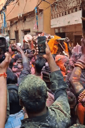 शव यात्रा के बीच भी घाट पर भस्म की होली खेली जा रही है।