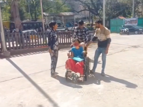 व्हीलचेयर पर मरीज को ले जाते परिजन।