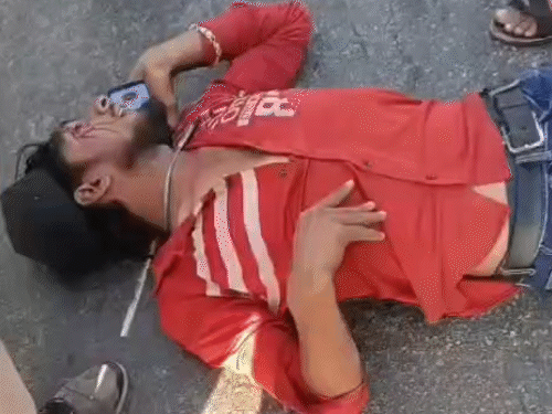 तबीयत बिगड़ने पर जमीन पर गिरा ट्रक ड्राइवर।