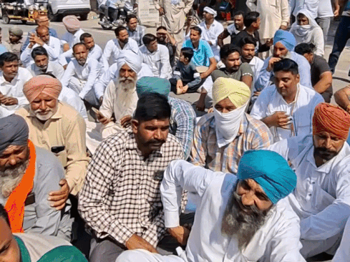 कलेक्ट्रेट के बाहर धरने पर बैठे किसान।