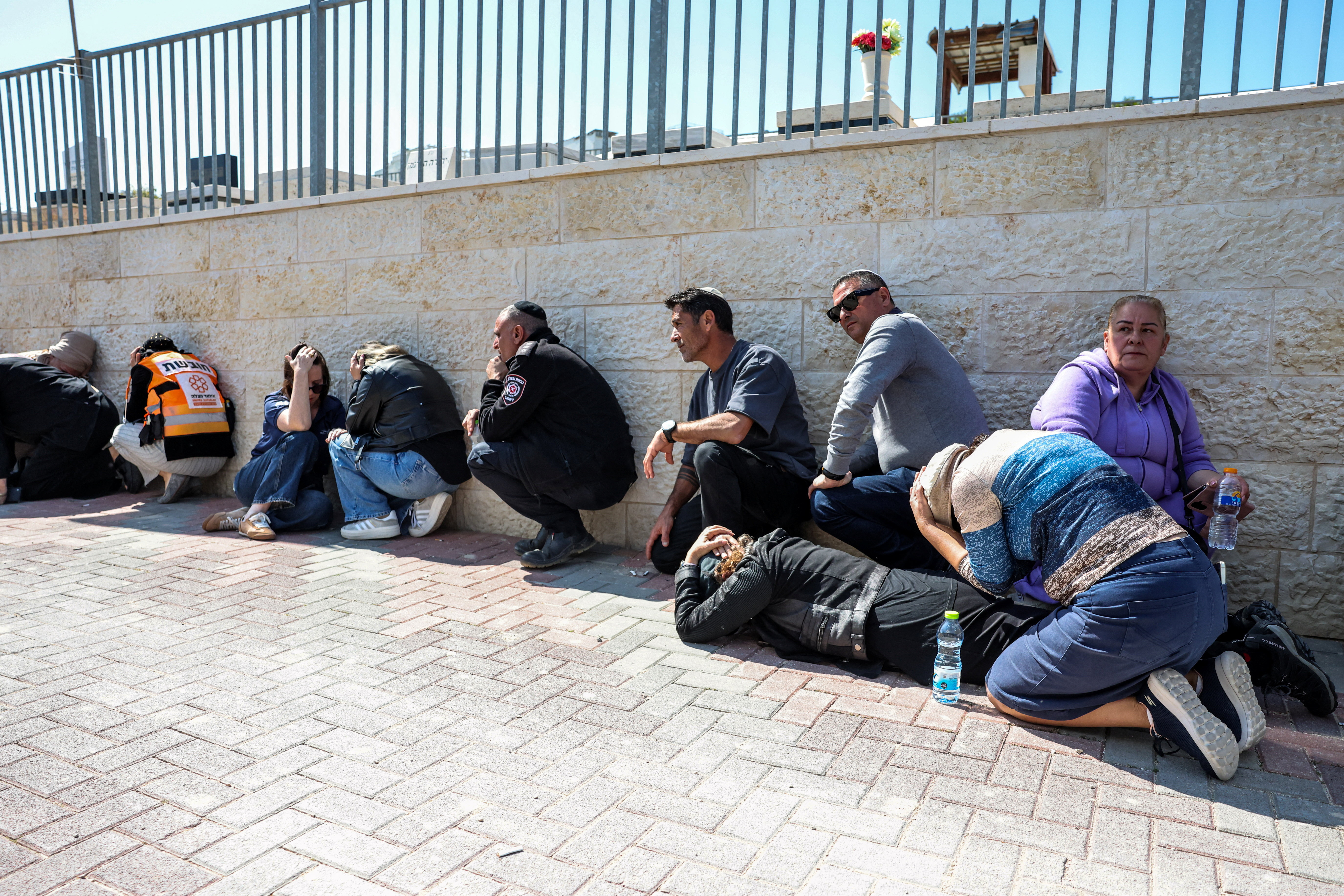 एक ईरानी मिसाइल हमले में मारी गई मां और बेटी के अंतिम संस्कार के दौरान सोमवार को इजराइल के बेइत शेमेश स्थित एक कब्रिस्तान में सायरन बजते ही शोक मनाने वाले लोग बचते दिखाई दिए।