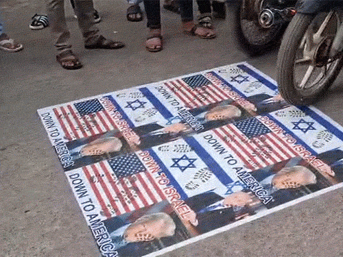 सड़क पर ट्रंप-नेतन्याहू के पोस्टर के ऊपर से गाड़ियां चलाईं, पैरों से रौंदा।