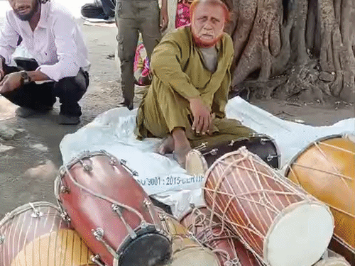 ढोलक बस्ती में सड़क किनारे बैठ ढोलक बेचते कारिगर।