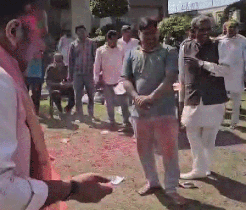 सोनीपत में विधायक निखिल मदान को कोरड़ा मारती महिला।