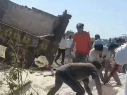 हाथों से नमक को हटाकर युवकों को बाहर निकालते हुए लोग।