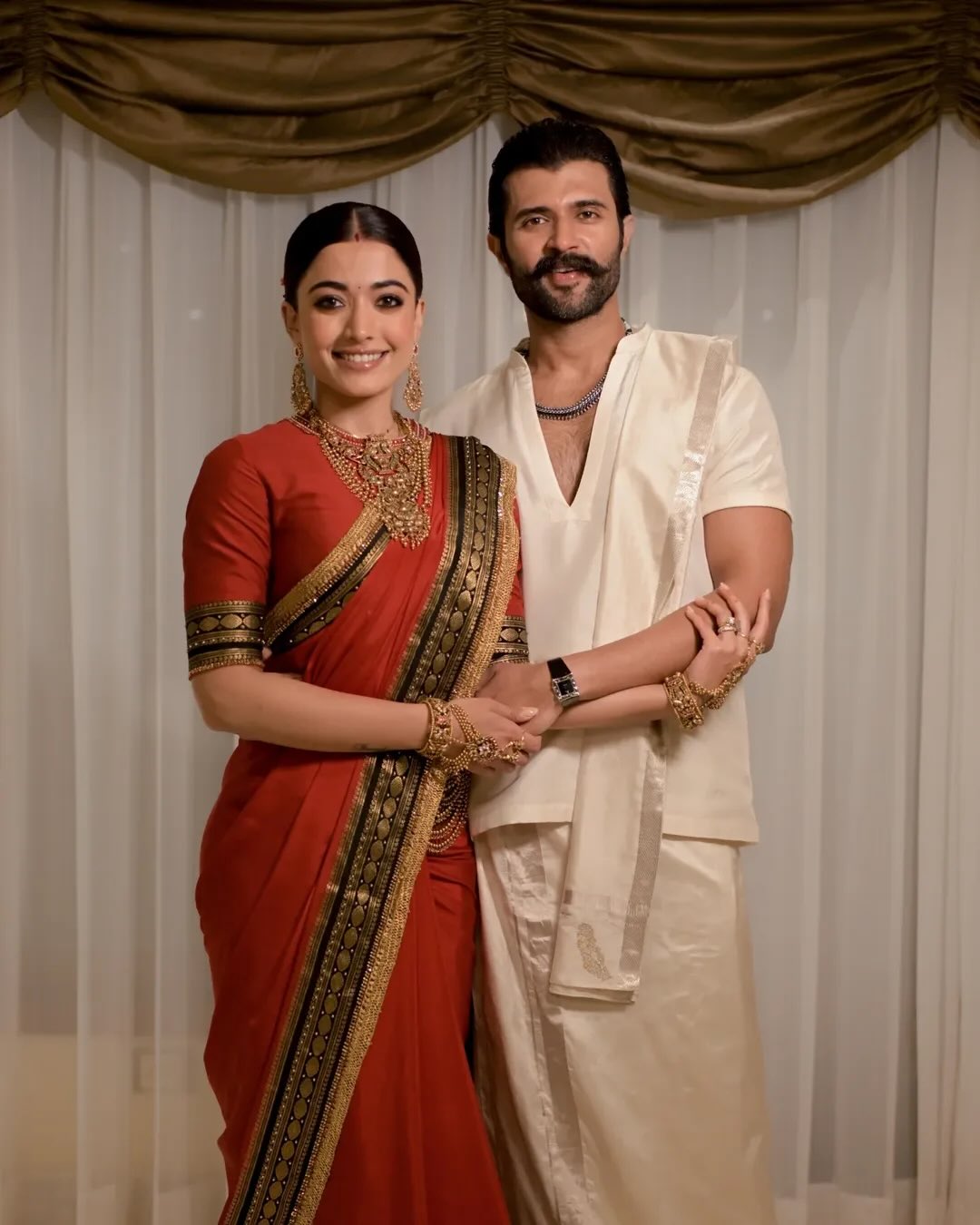 रिसेप्शन में रश्मिका ने डिजाइनर जेड बाय एमके की कस्टम लाल साड़ी और विजय ने व्हाइट ट्रेडिशनल आउटफिट पहना।