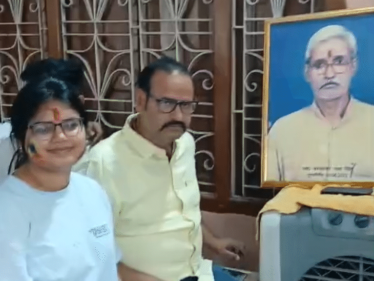 अपने दादा ब्रह्मेश्वर मुखिया की तस्वीर के पास पिता के साथ बैठी आकांक्षा।
