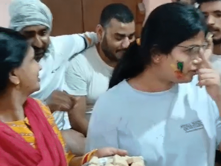 आकांक्षा को मिठाई खिलाती उनकी मां रिंकू देवी।