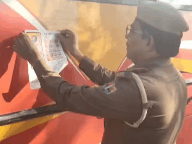 बस पर बैनर लगाते ट्रैफिक इंचार्ज राधेश्याम सांखला।