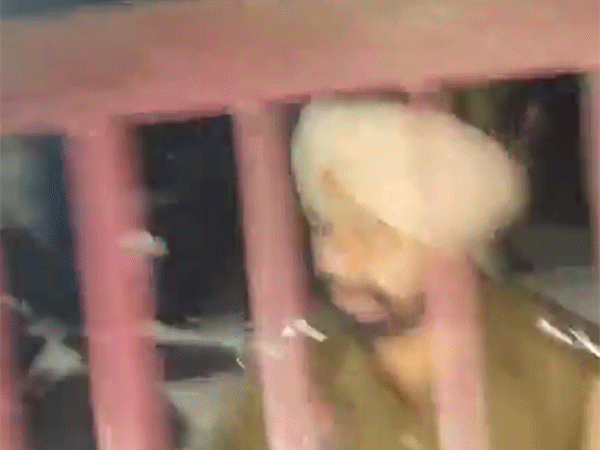 एसएचओ जयइंद्र थाने के बंद गेट से बात करते हुए।