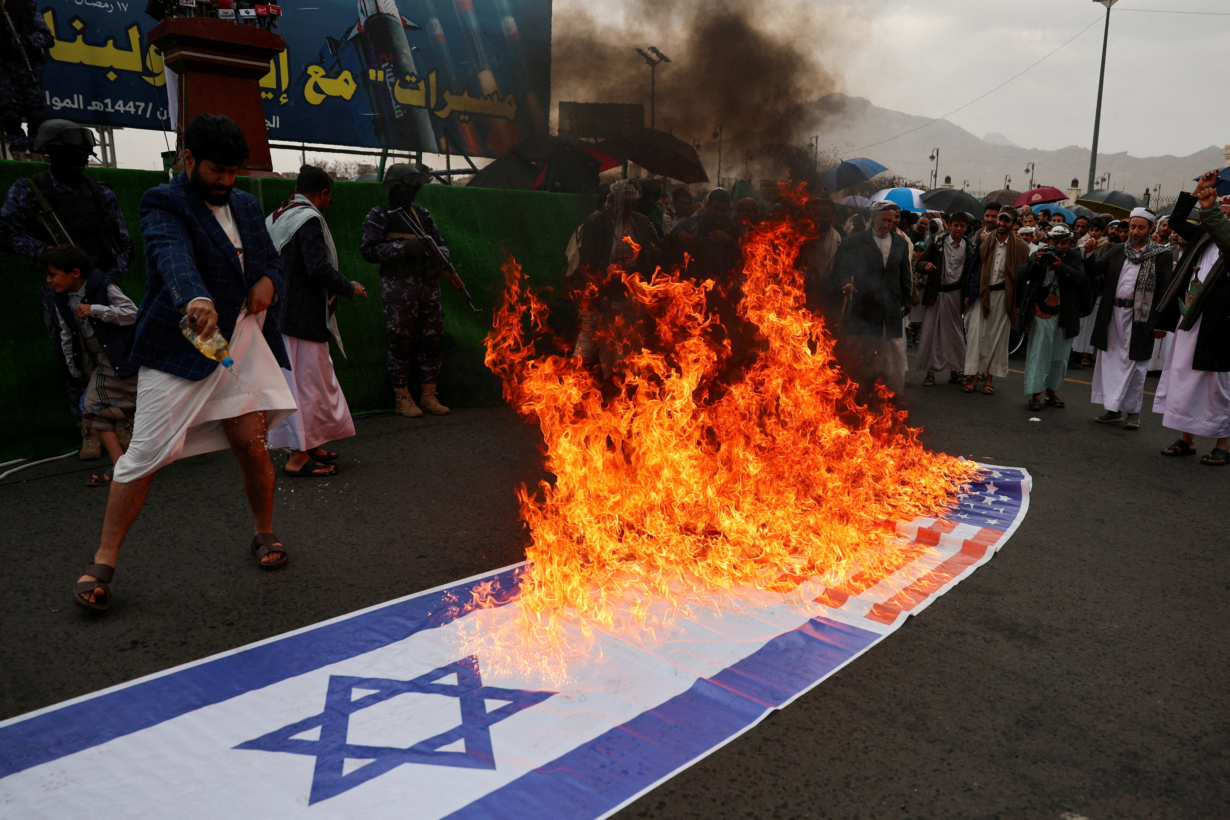 यमन के सना में, ईरान और लेबनान के साथ एकजुटता दिखाते हुए प्रदर्शन के दौरान हूती कार्यकर्ताओं ने अमेरिका और इजराइल के झंडे जलाए।