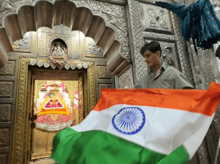 बाबा की प्रतिमा के सामने तिरंगा लगाकर जीत की कामना करते हुए।