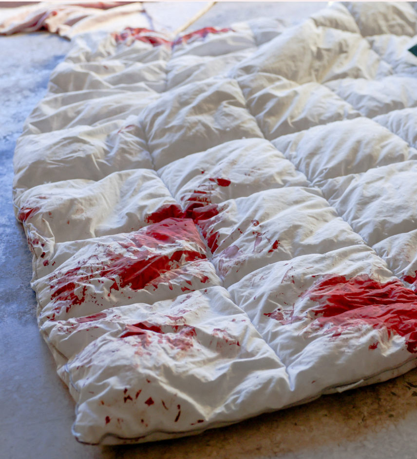 तस्वीर में होटल के बाहर जमीन पर पड़े रजाई पर खून के धब्बे दिखाई दे रहे हैं।