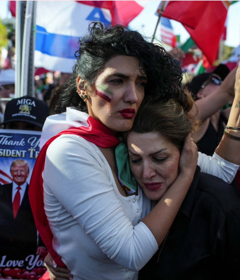 अमेरिका में ईरानी नेतृत्व के खिलाफ एक रैली के दौरान अपनी दोस्त को पकड़े हुए महिला।