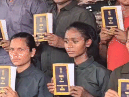 हाथ में संविधान की किताब लिए दिखे सरेंडर नक्सली।