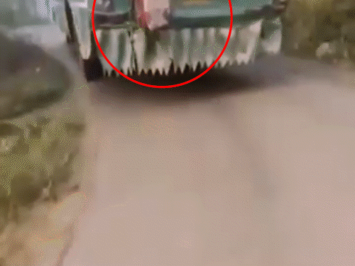 बस की सीढ़ी को पकड़कर सफर करते हुए स्कूली बच्चा।