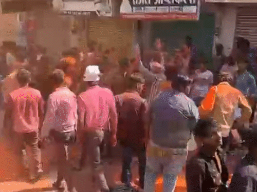 सवारी से पहले ढोल की धुन पर रंग-गुलाल उड़ाते हुए डांस करते युवा।