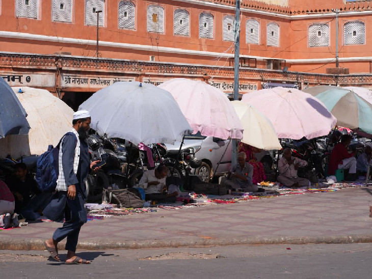 जयपुर परकोटे में सड़क किनारे दुकानदारों ने छातों का सहारा लिया।
