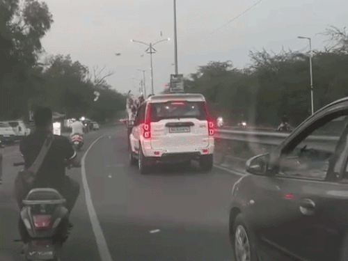 सड़क पर चलती जीप से डोली वाली स्कॉर्पियों पर नोट बरसाते हुए दूल्हे के दोस्त।