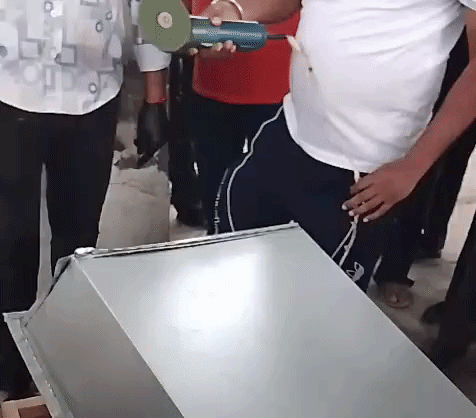 श्मशानघाट में शव को निकालने के लिए लोहे के बॉक्स को काटते हुए।