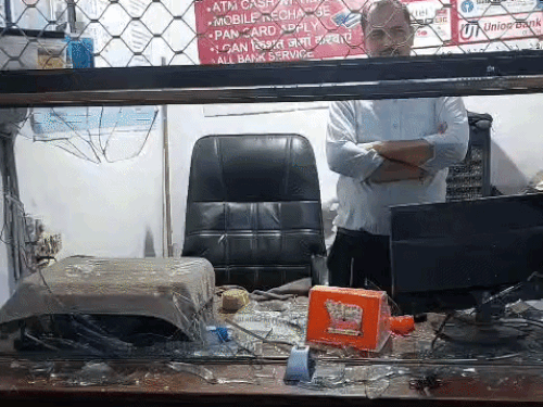 टूटे शीशे दिखाता दुकानदार विनय।
