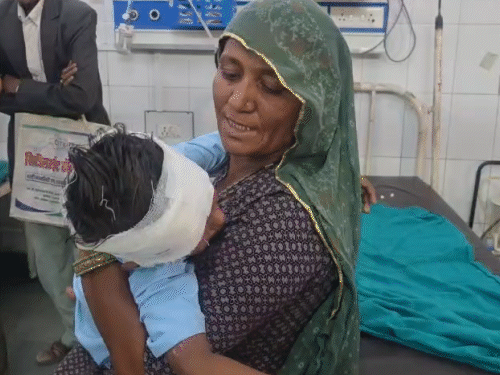 घायल बच्चे को गोद में लेकर दुलारती मां।