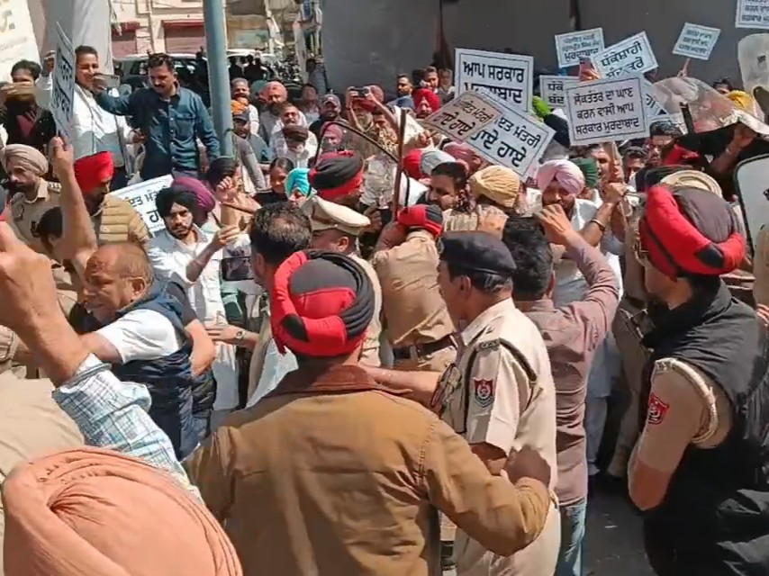 प्रदर्शनकारियों को रोकते पुलिस कर्मी।