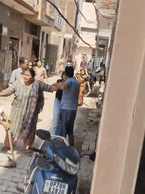 एक महिला ने युवक पर फावड़े से हमला करने की कोशिश की, लेकिन दूसरी महिला ने उसे धक्का देकर रोक दिया।