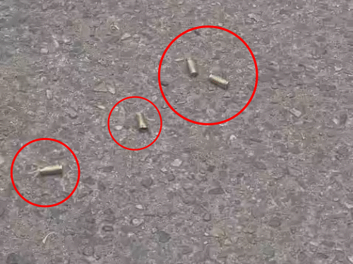 सड़क पर पड़े खाली खोल, जो पुलिस ने कब्जे में ले लिए हैं।