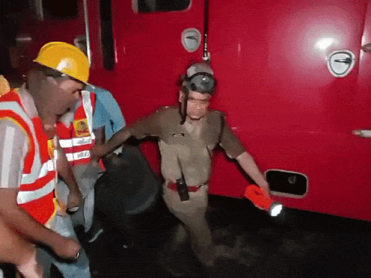 शवों के घर के अंदर से निकालकर ले जाते दमकल कर्मी।