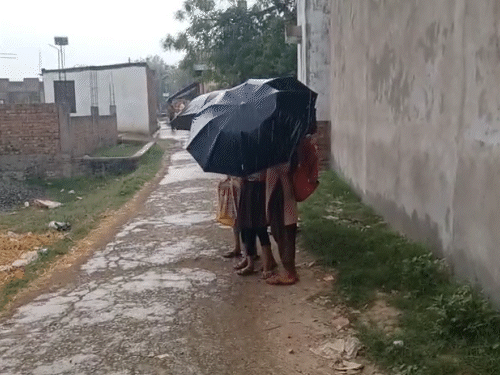 भदोही में अचनाक मौसम बदल गया। स्कूल के लिए निकले बच्चे छाते से खुद को बचाते नजर आए।