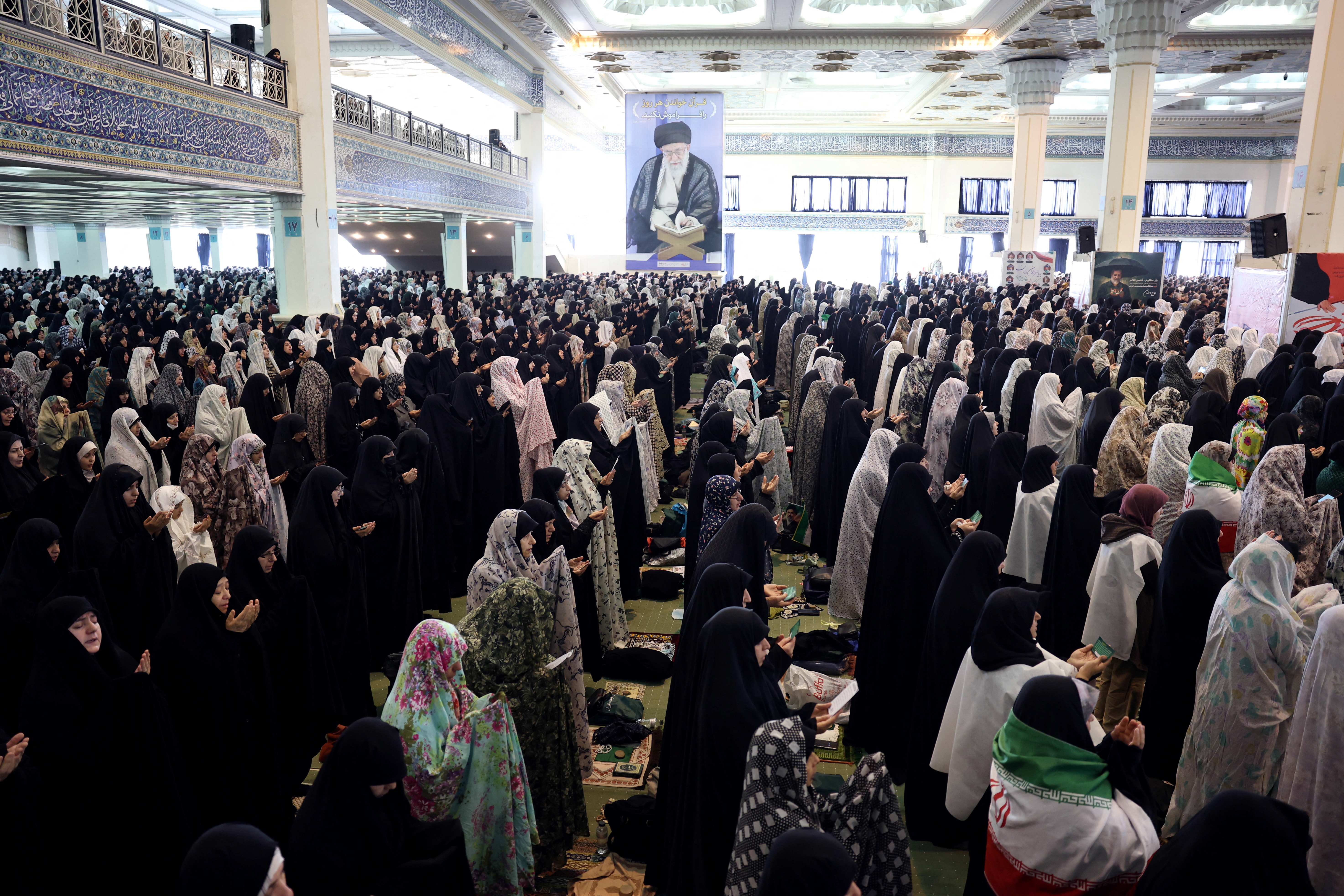तेहरान के ग्रैंड मोसल्ला मस्जिद में शनिवार को ईरानी शिया मुस्लिमों ने ईद उल फितर की नमाज अदा की। दीवार पर आयतोल्ला अली खामेनेई की तस्वीर लगी है।