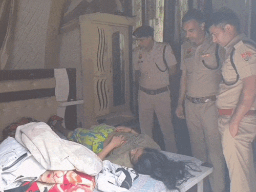 महिला की हत्या के बाद जांच करते पुलिस अधिकारी।